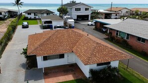 Un barrio residencial con casas, un camino de entrada y vista al océano.
