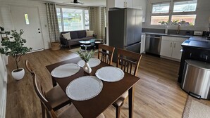 Una cocina moderna con comedor, sofá y refrigerador.