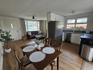 Eine moderne Küche mit Essbereich, einer Couch und einem Kühlschrank.