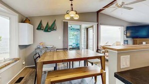 Eine moderne Küche mit Holztisch, einer integrierten Kochinsel und einem Deckenventilator.