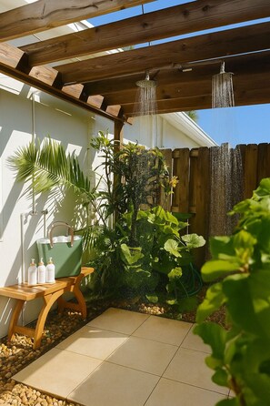 Eine Terrasse mit einer Holzhütte, einer grünen Tragetasche und einem kleinen Tisch mit Flaschen.