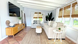 Una sala de estar con sofá, mesa de centro, televisor y un mueble de madera.