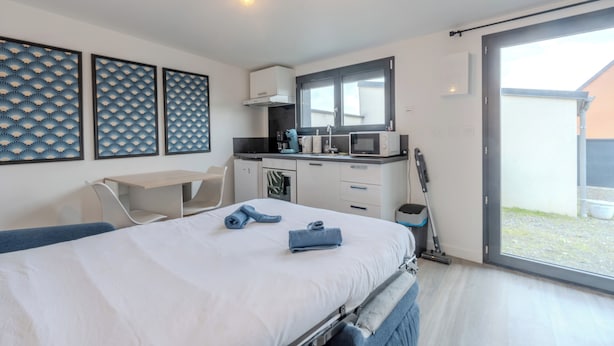 Una camera da letto moderna con un letto, una scrivania e un angolo cottura.