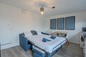 Une petite pièce comprenant un lit, un bureau et une chaise.