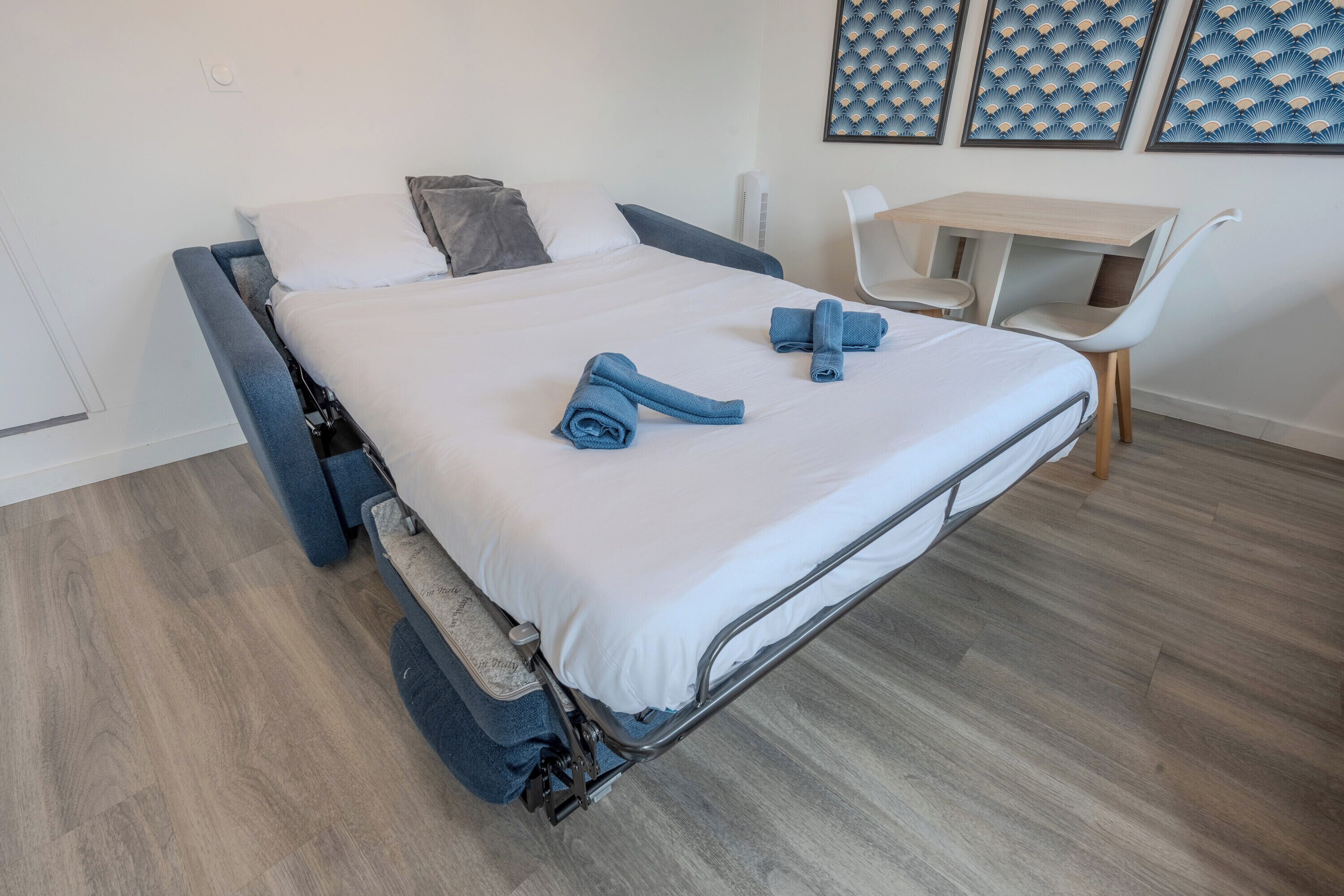 Une chambre à coucher moderne avec un lit, un bureau et des chaises.