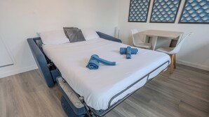 Una camera da letto moderna con un letto, una scrivania e delle sedie.