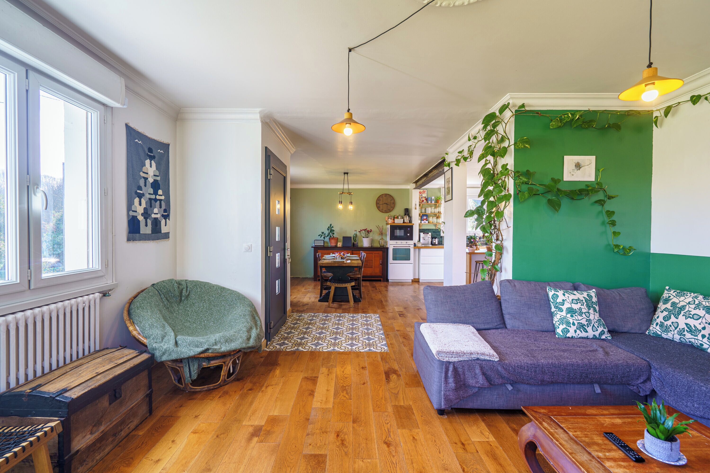 A cozy living room with a sofa, a wooden coffee table, and a wicker chair.