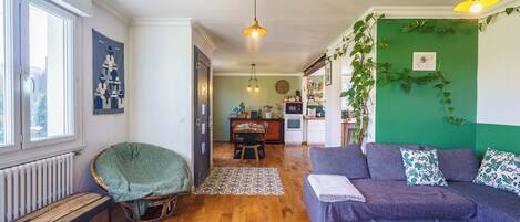 A cozy living room with a sofa, a wooden coffee table, and a wicker chair.