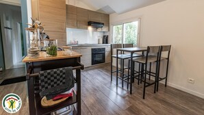 Eine moderne Küche mit Holzausstattung, einem eingebauten Backofen und einem Essbereich mit Tisch und Stühlen.