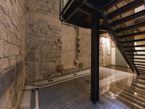 A stone-walled corridor with a modern staircase and a tiled floor. - Bravissimo Nou 3, two bedroom centre apartment near Pont de Pedra (Girona)