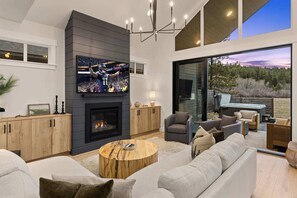 A modern living room with a fireplace, comfortable seating, and a large TV screen. - 5BR Meadow Mt View, Hot Tub, BBQ, Chefs Kitch (Cle Elum)
