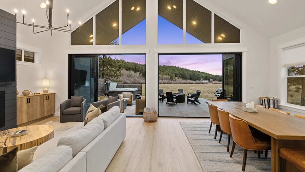 Un amplio espacio de estar con una gran mesa de comedor, asientos cómodos y vistas al exterior.