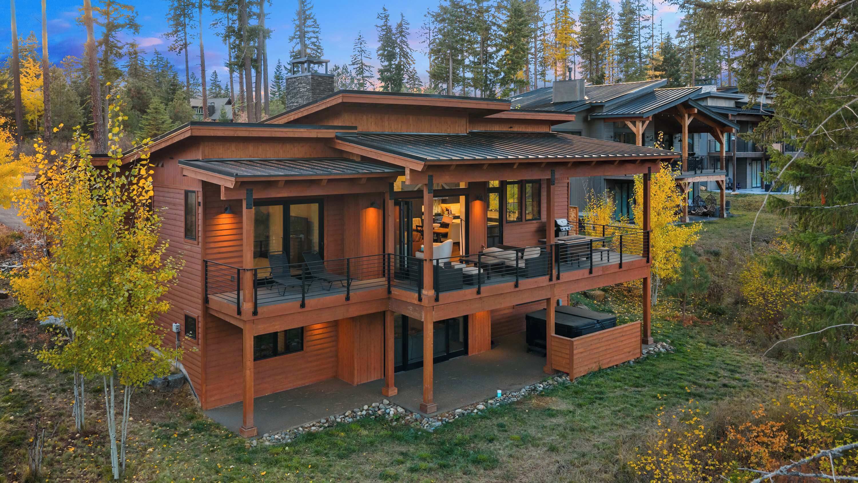 Secluded retreat nestled among trees with expansive outdoor living areas.