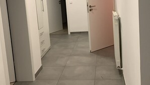 A hallway with a white door, a pink door, and a white wardrobe. - Exceptional romantic vacation apartment Sonnenschein Weinheim am Waidsee (Weinheim)
