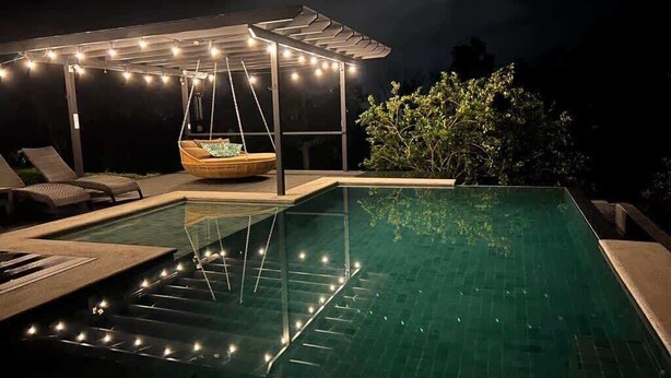 A swimming pool with a swing chair, a covered seating area, and string lights. - Studio w/Pool • Near Downtown Turrialba (Turrialba)