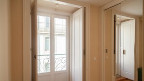 A hallway with a glass door leading to a balcony with a metal railing. - FLH Downtown City Elegance Apartment (Lisboa ciudad)