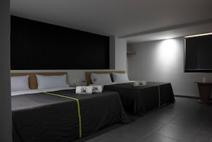 A hotel room with two beds, a large window, and a flat-screen TV.