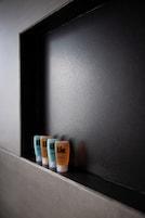 Une étagère avec trois bouteilles de shampoing.