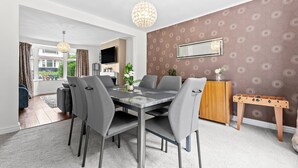 Un coin repas avec une table, des chaises et un téléviseur fixé au mur.