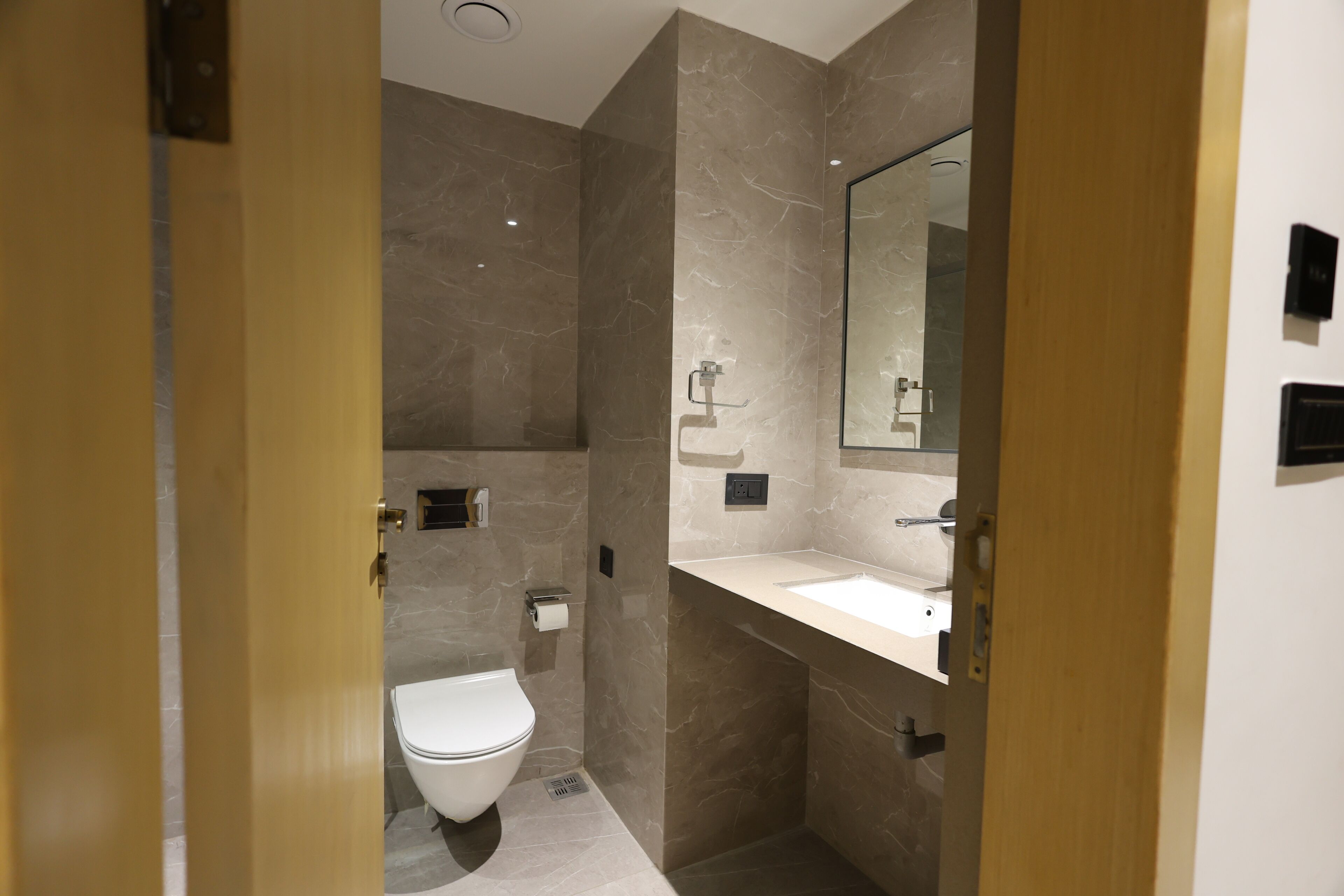 Un baño moderno con inodoro, lavabo y espejo.