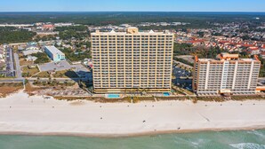 Un hôtel de grande hauteur, avec de nombreux étages, une piscine et un emplacement en bord de mer.