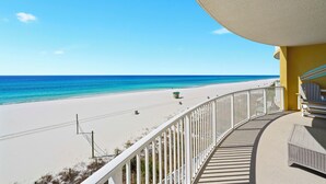Un balcon avec vue sur une plage et l’océan.