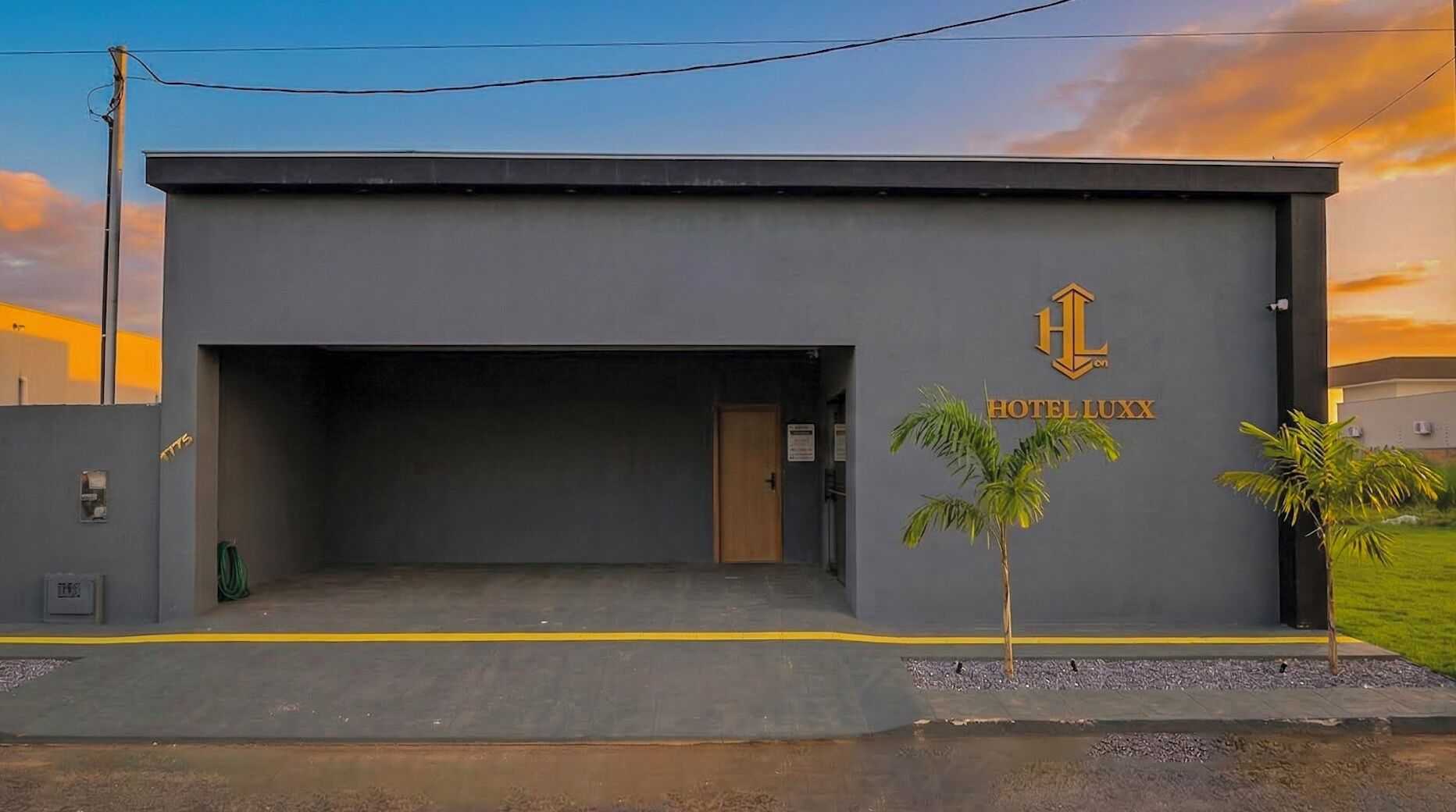 A building with a sign reading 'HOTEL LUXX' and a logo above it.