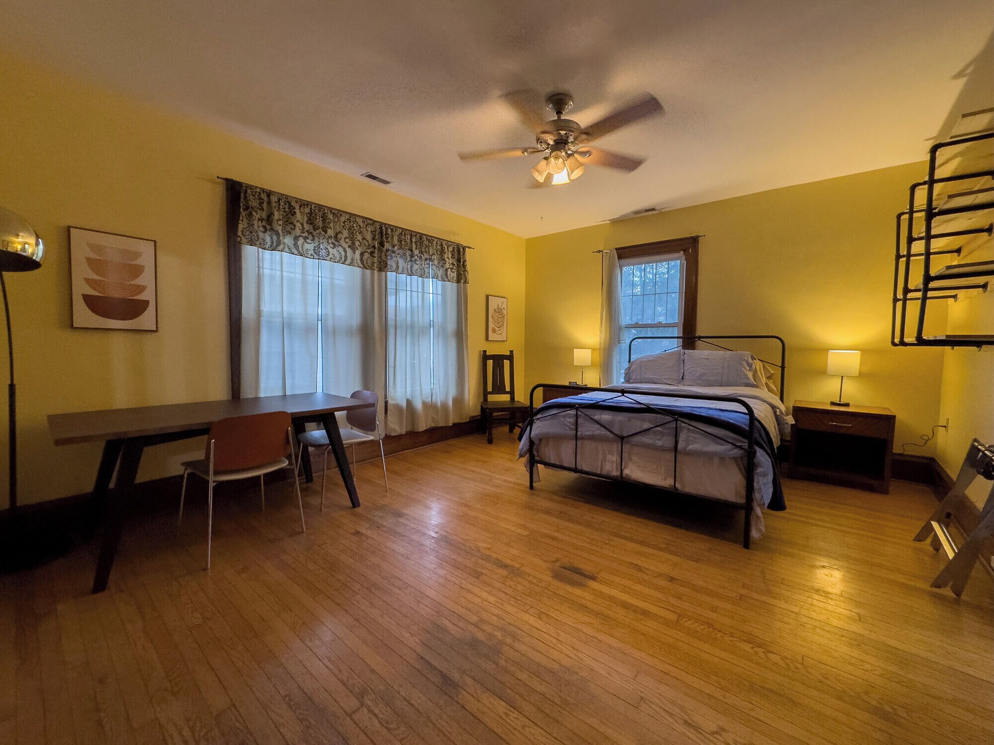 A bedroom with a bed, a desk, and a chair.