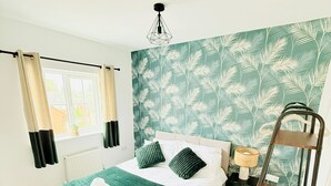 Une chambre à coucher avec un lit, une table de chevet, une lampe, une fenêtre avec des rideaux et un lit superposé.