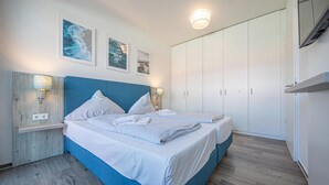 Un dormitorio con cama, armario e iluminación en la pared.