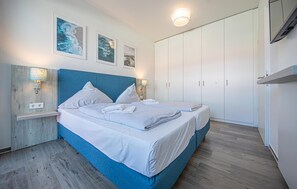 A bedroom with a bed, a wardrobe, and wall-mounted lights. - Nice apartment in OstseeResort Olpenitz with sauna (OstseeResort Olpenitz)