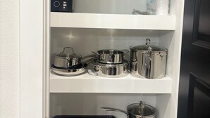A kitchen with a coffee maker, blender, and various pots on shelves. - High End Luxury 3bedroom Located Near Downtown Houston (Houston)