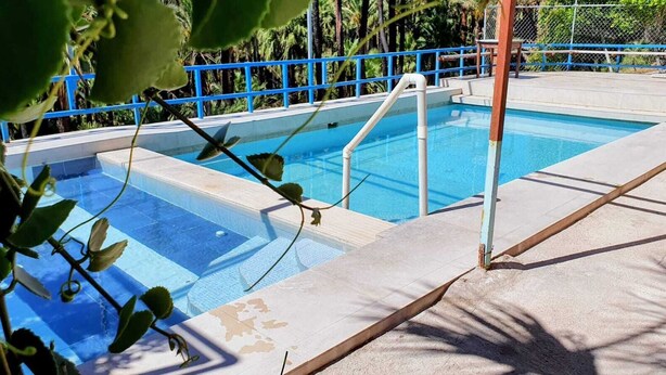 Una piscina con ringhiere blu e scalini che conducono all'acqua.