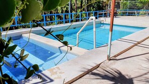 Piscina com guarda-corpo azul e degraus para entrar na água.