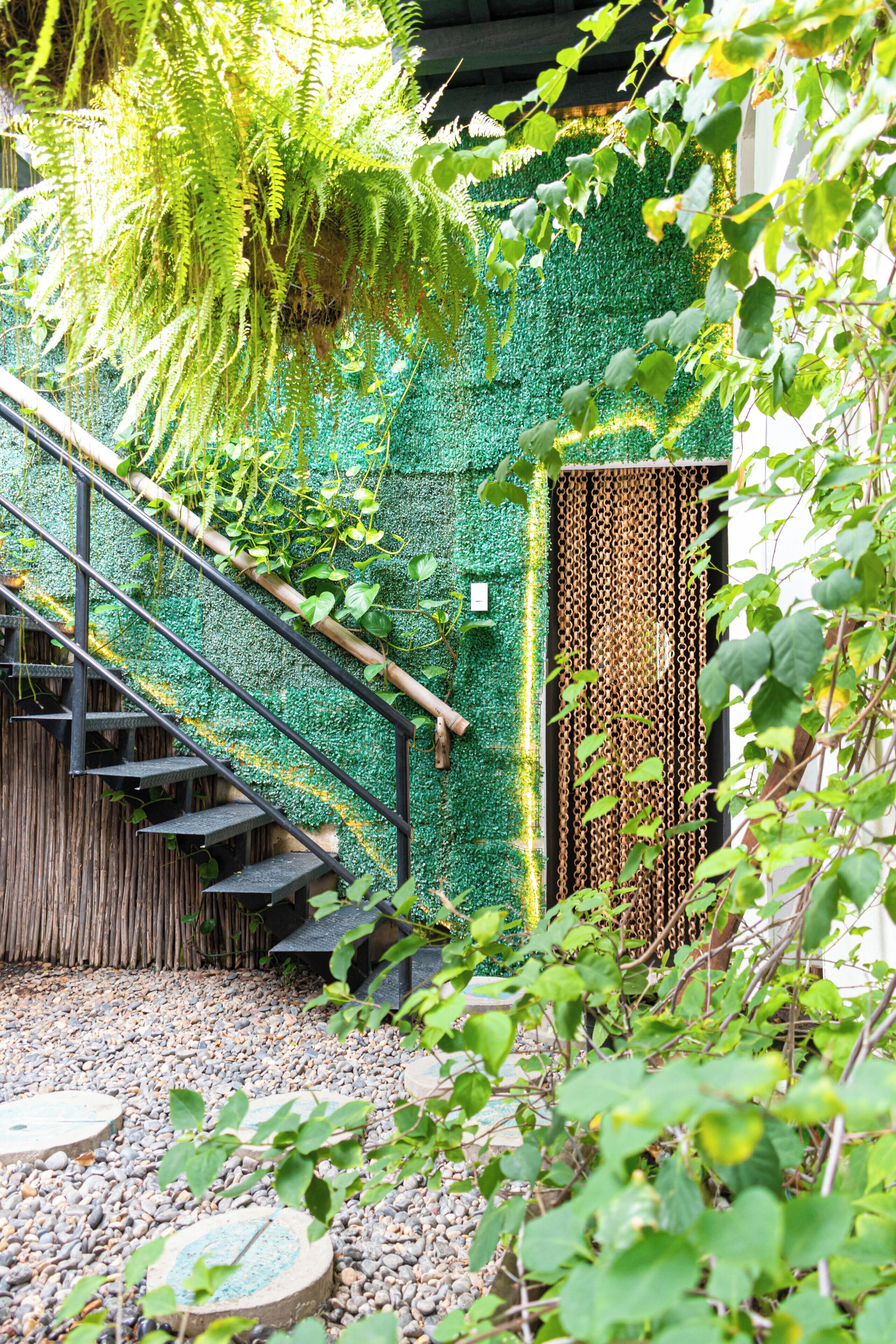 Eine Treppe führt zu einem Raum mit grüner Wand und einem Drahtzaun.