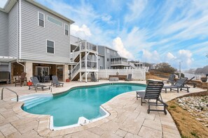 A pool area with lounge chairs, a hot tub, and a deck with a railing. - Luxe Sandbridge Beach, Waterfront, Pool, Arcade (Virginia Beach)