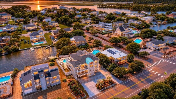 Zona residencial com casas, piscina e vista para o rio.