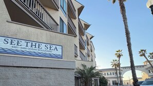 Ein mehrgeschossiges Gebäude mit einem Schild, auf dem „SEE THE SEA“ steht, und Blick auf den Ozean im Hintergrund.