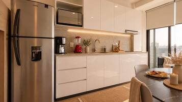 Cafetera o tetera, frigorífico, microondas y placa de cocina