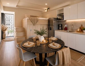A compact living space with a dining area, kitchenette, and a bed. - Trendy Loft | Walk to Guadalajara's Best Spots (Guadalajara)