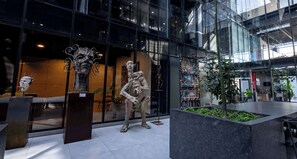 A modern building with glass facades, sculptures, and indoor plants. - Trendy Loft | Walk to Guadalajara's Best Spots (Guadalajara)