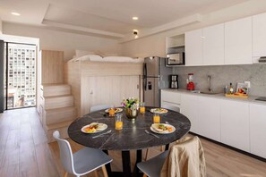 Une cuisine compacte avec un coin repas, un lit escamotable et une vue sur la ville.