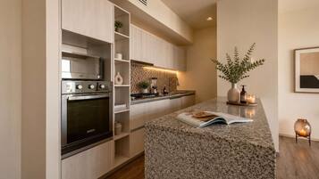 A modern kitchen with a built-in oven, a microwave, and a granite countertop.