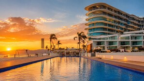 A modern hotel with a pool, palm trees, and a sunset view. - Beach, Pool & Relaxation in Nuevo Vallarta (Nuevo Vallarta)