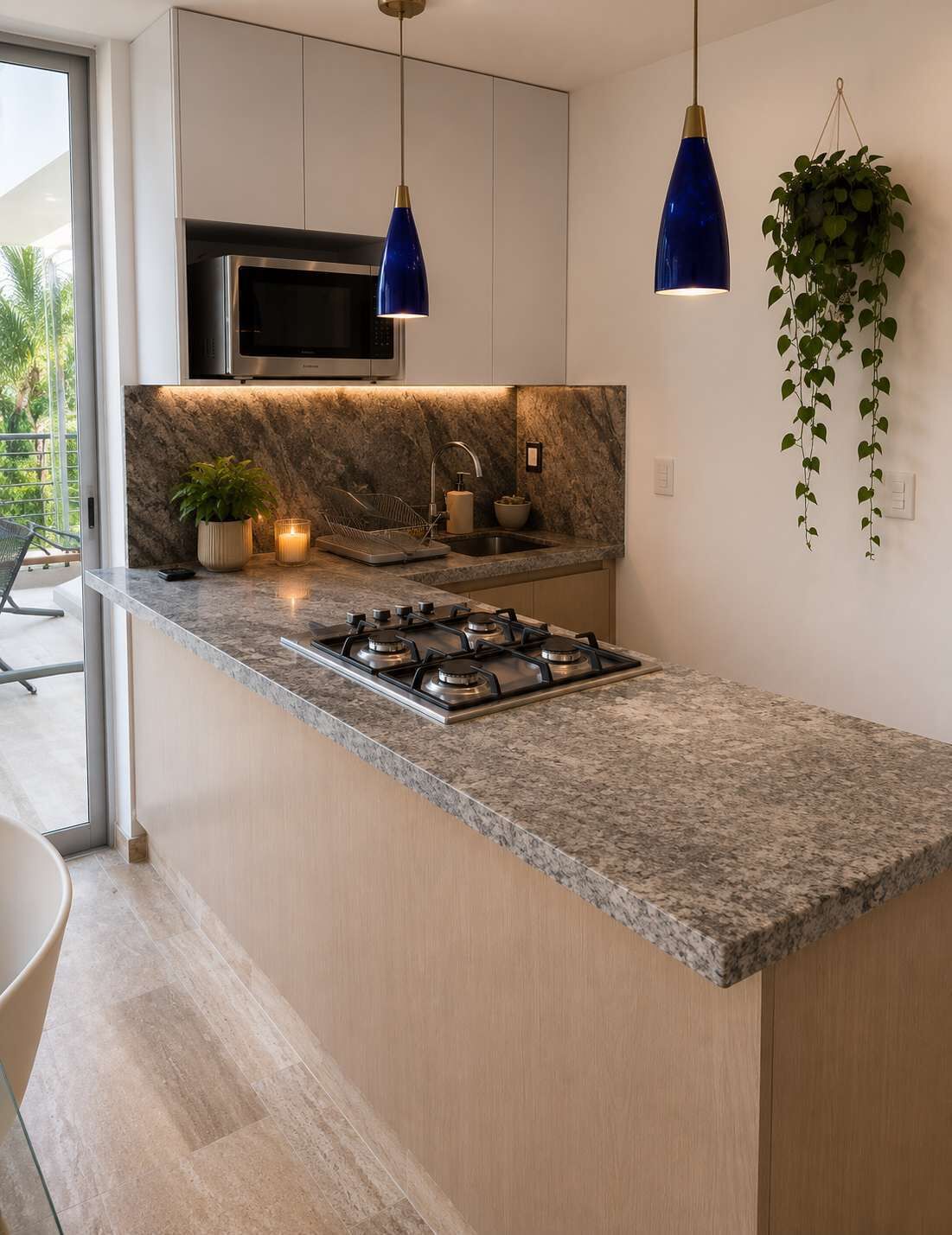 A modern kitchen with a granite countertop, stainless steel appliances, and pendant lighting.