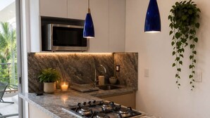 A modern kitchen with a granite countertop, stainless steel appliances, and pendant lighting. - Beach, Pool & Relaxation in Nuevo Vallarta (Nuevo Vallarta)
