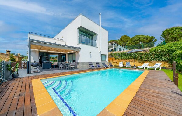A modern house with a swimming pool, outdoor seating, and a covered patio. - Luxurious home in BLANES (BLANES)