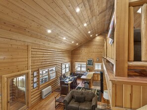 L’intérieur d’une cabane en rondins comprend un coin repas, une cuisine et un espace salon confortable.