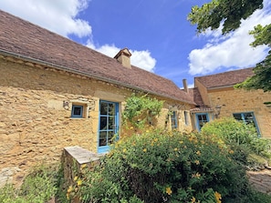 A stone building with a tiled roof, a small window, and a door. - Au coeur des Valades, private swimming pool (COUX ET BIGAROQUE)