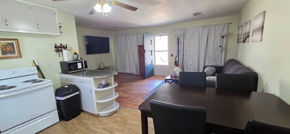 A compact living space with a kitchenette, dining area, and a sofa.